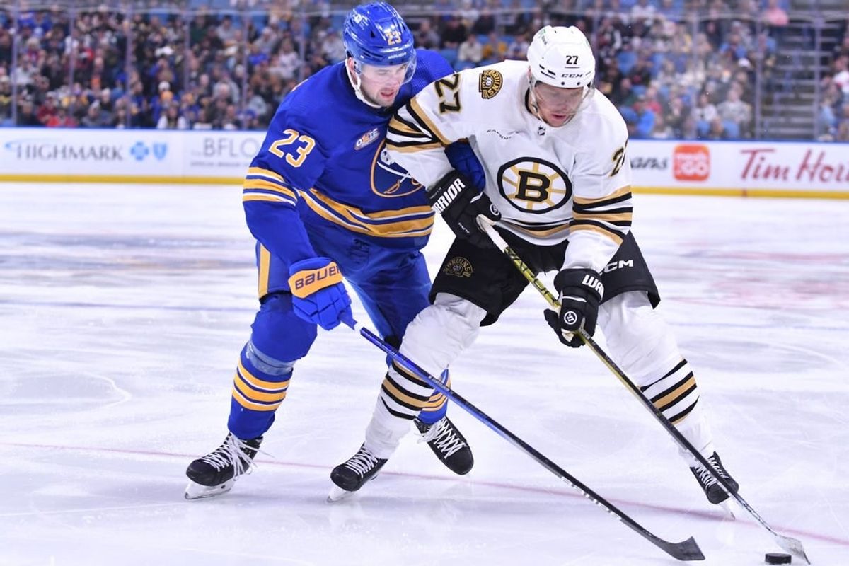 Nov 14, 2023; Buffalo, New York, USA; Boston Bruins defenseman Hampus Lindholm (27) and Buffalo Sabres defenseman Mattias Samuelsson (23) battle for the puck in the first period at KeyBank Center.