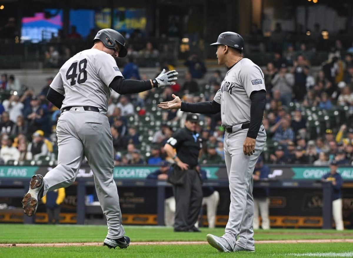 Apr 28, 2024; Milwaukee, Wisconsin, USA; New York Yankees first base Anthony Rizzo (48) is congratulated by New York Yankees third base coach Luis Rojas (67) after hitting his 300th career home run in the eighth inning against the Milwaukee Brewers at American Family Field.