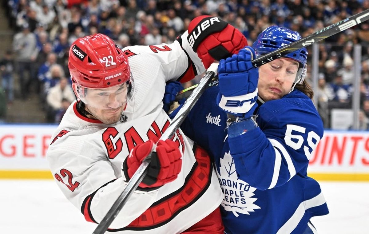 Dec 30, 2023; Toronto, Ontario, CAN; Carolina Hurricanes defenseman Brett Pesce (22) battles for position with Toronto Maple Leafs forward Tyler Bertuzzi (59) in the first period at Scotiabank Arena.