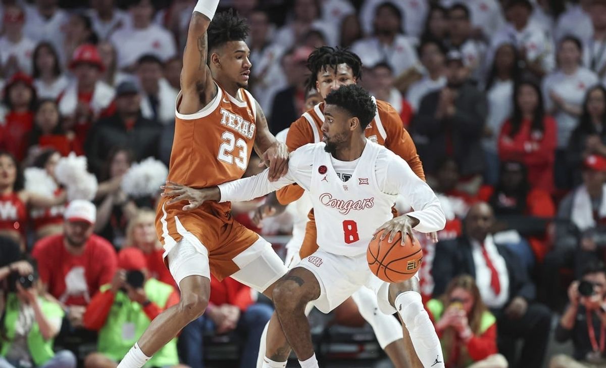 Feb 17, 2024; Houston, Texas, USA; Texas Longhorns forward Dillon Mitchell (23) defends against Houston Cougars guard Mylik Wilson (8) during the first half at Fertitta Center.