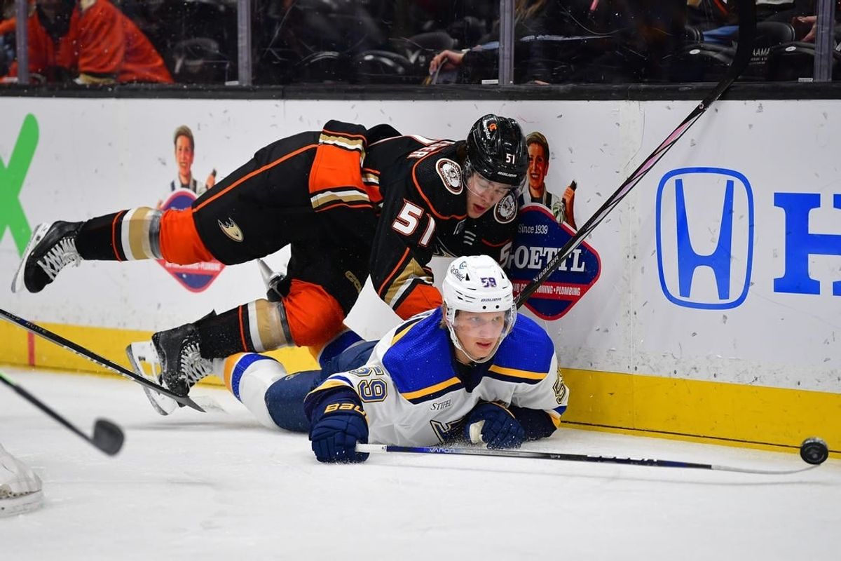 Apr 7, 2024; Anaheim, California, USA; Anaheim Ducks defenseman Olen Zellweger (51) plays for the puck against St. Louis Blues center Nikita Alexandrov (59) during the first period at Honda Center.