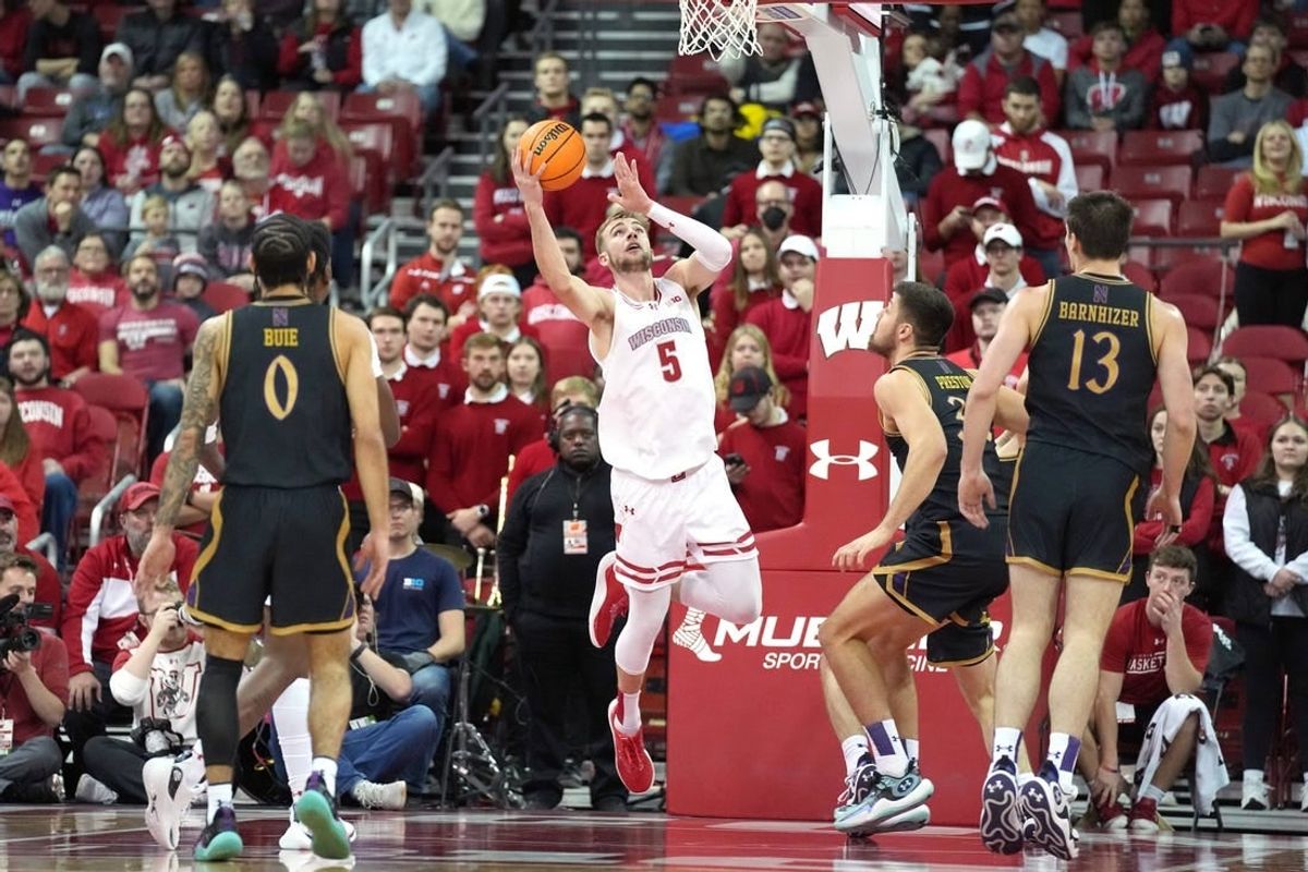 Jan 13, 2024; Madison, Wisconsin, USA; Wisconsin Badgers forward Tyler Wahl (5) scores against Northwestern Wildcats forward Blake Preston (32) during the first half at the Kohl Center.