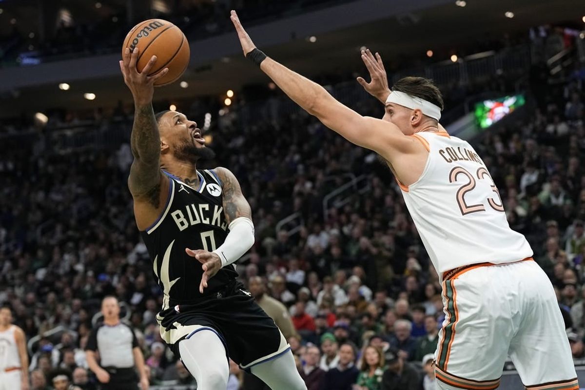 Dec 19, 2023; Milwaukee, Wisconsin, USA;  Milwaukee Bucks guard Damian Lillard (0) shoots around San Antonio Spurs center Zach Collins (23) during the first quarter at Fiserv Forum.