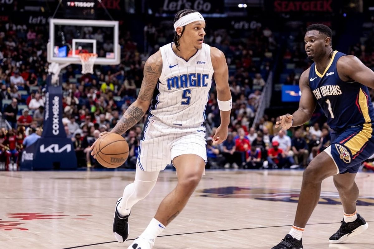 Apr 3, 2024; New Orleans, Louisiana, USA;  Orlando Magic forward Paolo Banchero (5) brings the ball up court against New Orleans Pelicans forward Zion Williamson (1) during the first half at Smoothie King Center.