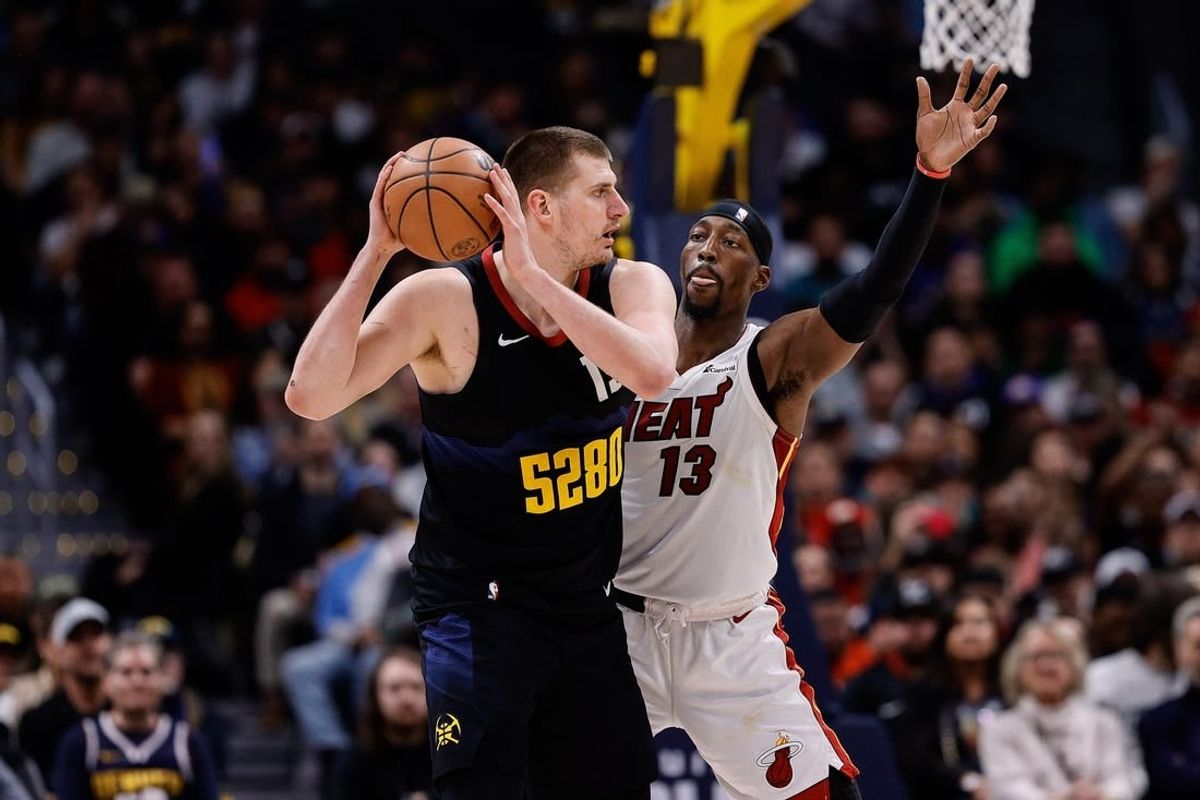 Feb 29, 2024; Denver, Colorado, USA; Denver Nuggets center Nikola Jokic (15) controls the ball as Miami Heat center Bam Adebayo (13) guards in the fourth quarter at Ball Arena.