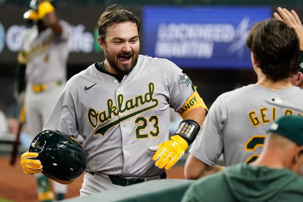 Apr 9, 2024; Arlington, Texas, USA; Oakland Athletics catcher Shea Langeliers (23) is greeted at the dugout after hitting a solo home run during the seventh inning against the Texas Rangers at Globe Life Field.