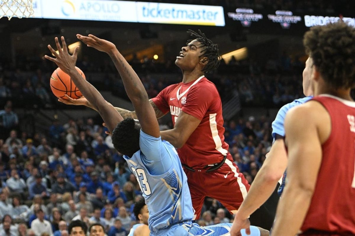 Dec 16, 2023; Omaha, Nebraska, USA; Alabama Crimson Tide forward Nick Pringle (23) drives against Creighton Bluejays center Fredrick King (33) in the first half  at CHI Health Center Omaha.