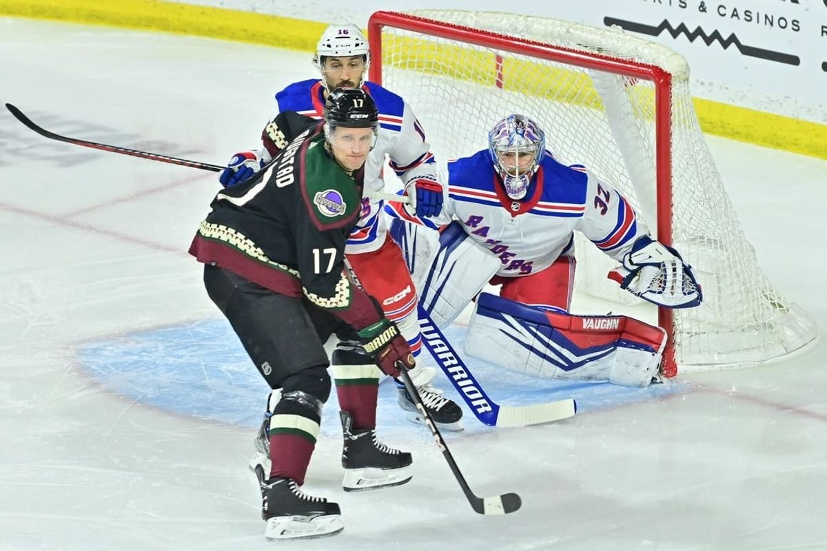 Mar 30, 2024; Tempe, Arizona, USA;  New York Rangers goaltender Jonathan Quick (32) defends as Arizona Coyotes center Nick Bjugstad (17) and center Vincent Trocheck (16) battle for position in the first period at Mullett Arena.