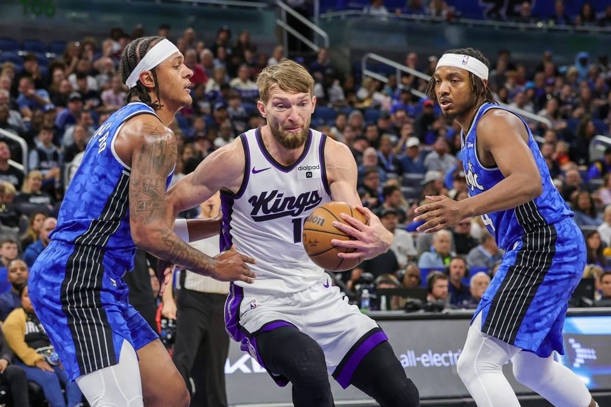 Mar 23, 2024; Orlando, Florida, USA; Sacramento Kings forward Domantas Sabonis (10) drives to the basket against Orlando Magic forward Paolo Banchero (5) and Orlando Magic center Wendell Carter Jr. (34) during the first quarter at KIA Center.