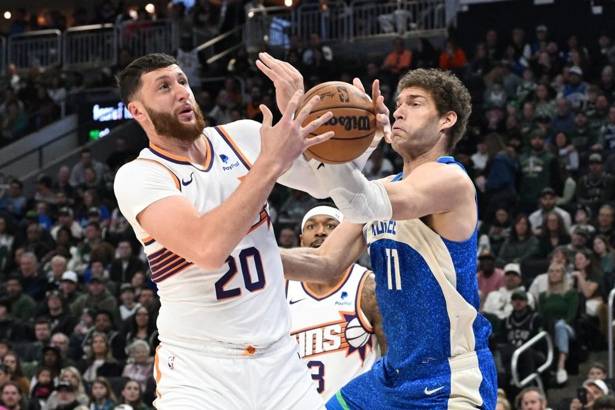 Mar 17, 2024; Milwaukee, Wisconsin, USA; Phoenix Suns center Jusuf Nurkic (20) and Milwaukee Bucks center Brook Lopez (11) battle for possession of the ball in the first half at Fiserv Forum.