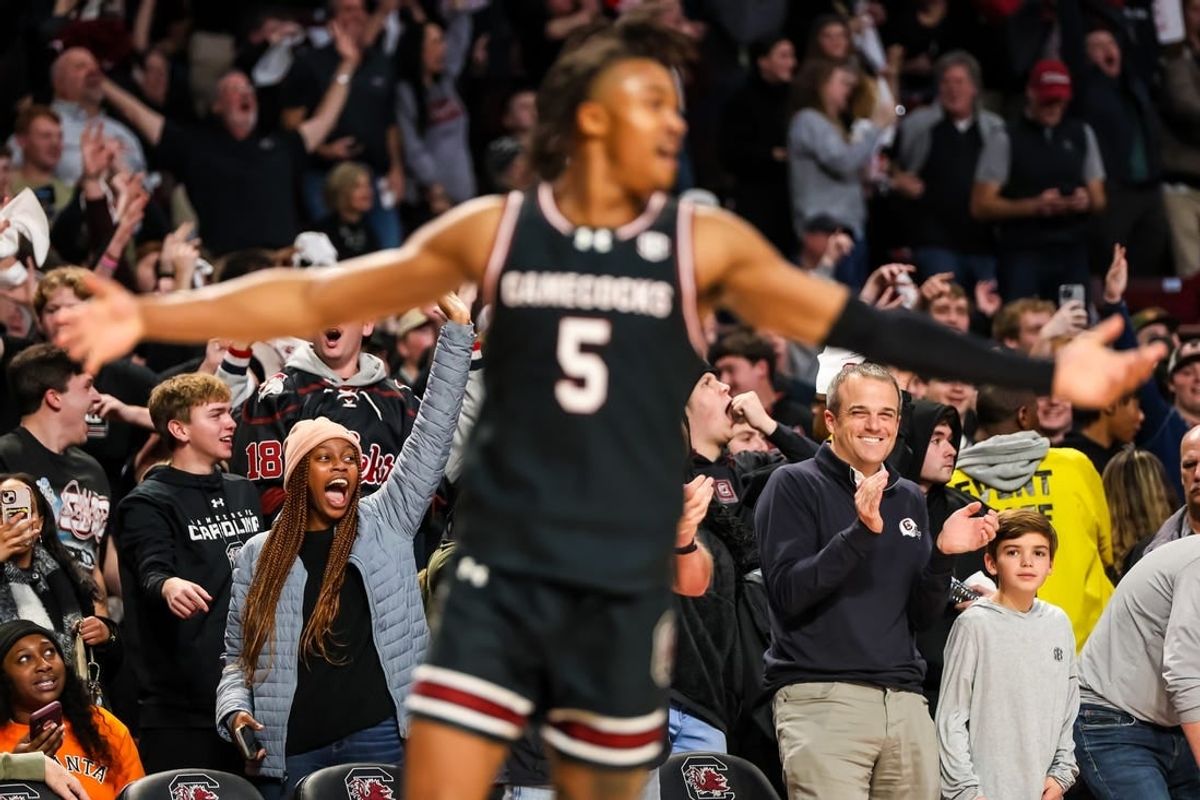 Jan 23, 2024; Columbia, South Carolina, USA; South Carolina Gamecocks head football coach Shane Beamer, bottom right, celebrates a three point basket by guard Meechie Johnson (5), foreground, against the Kentucky Wildcats in the second half at Colonial Life Arena.