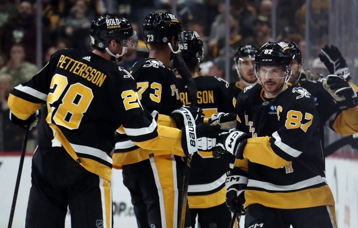 Apr 11, 2024; Pittsburgh, Pennsylvania, USA; Pittsburgh Penguins defenseman Marcus Pettersson (28) and defenseman Pierre-Olivier Joseph (73) congratulate center Sidney Crosby (87) on his goal against the Detroit Red Wings during the second period at PPG Paints Arena.