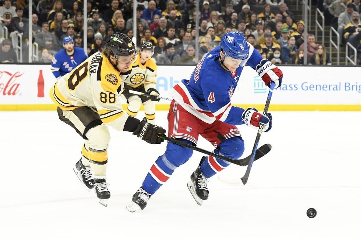 Dec 16, 2023; Boston, Massachusetts, USA;  Boston Bruins right wing David Pastrnak (88) and New York Rangers defenseman Braden Schneider (4) battle for the puck during the first period at TD Garden.