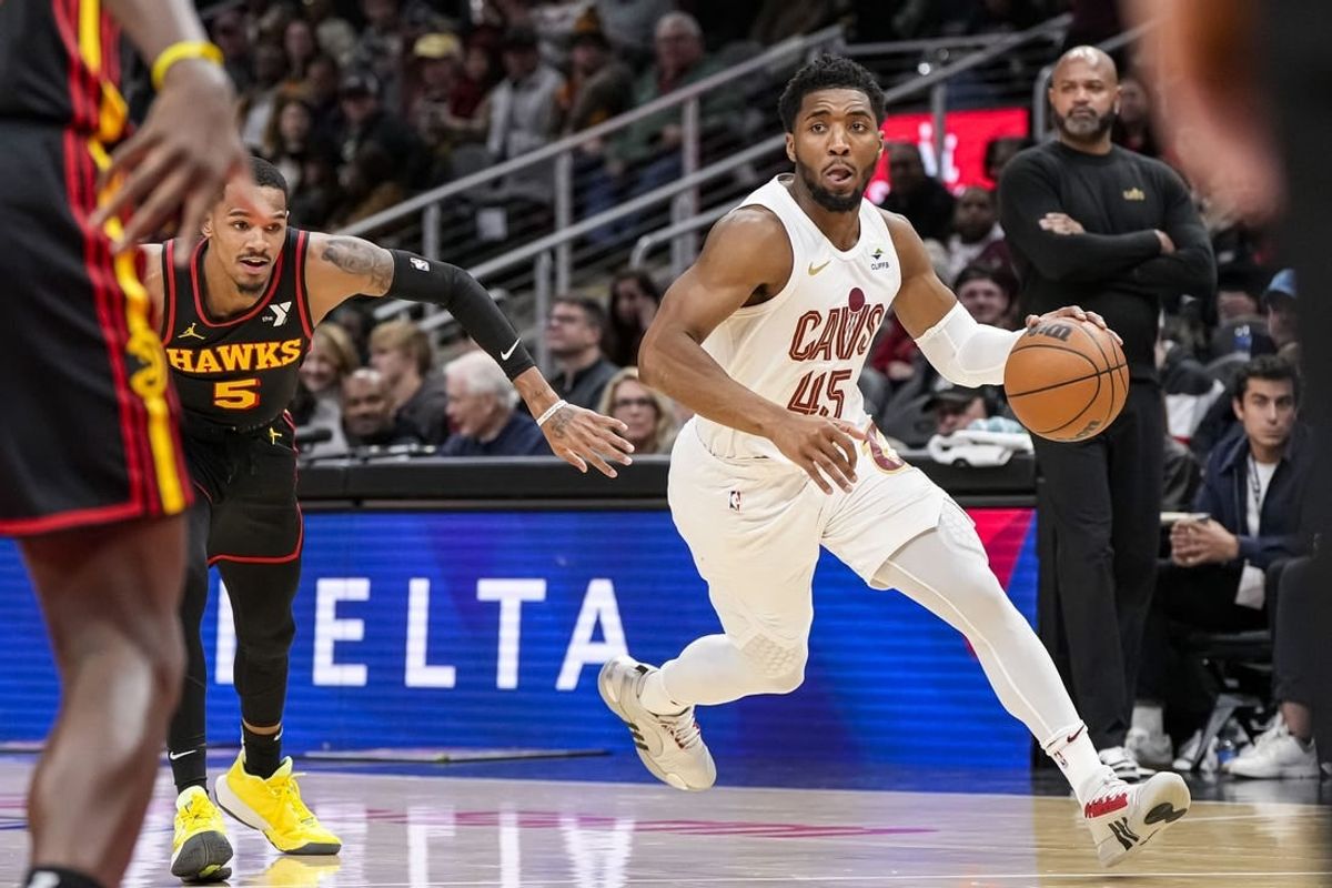 Jan 20, 2024; Atlanta, Georgia, USA; Cleveland Cavaliers guard Donovan Mitchell (45) dribbles past Atlanta Hawks guard Dejounte Murray (5) during the first half at State Farm Arena.