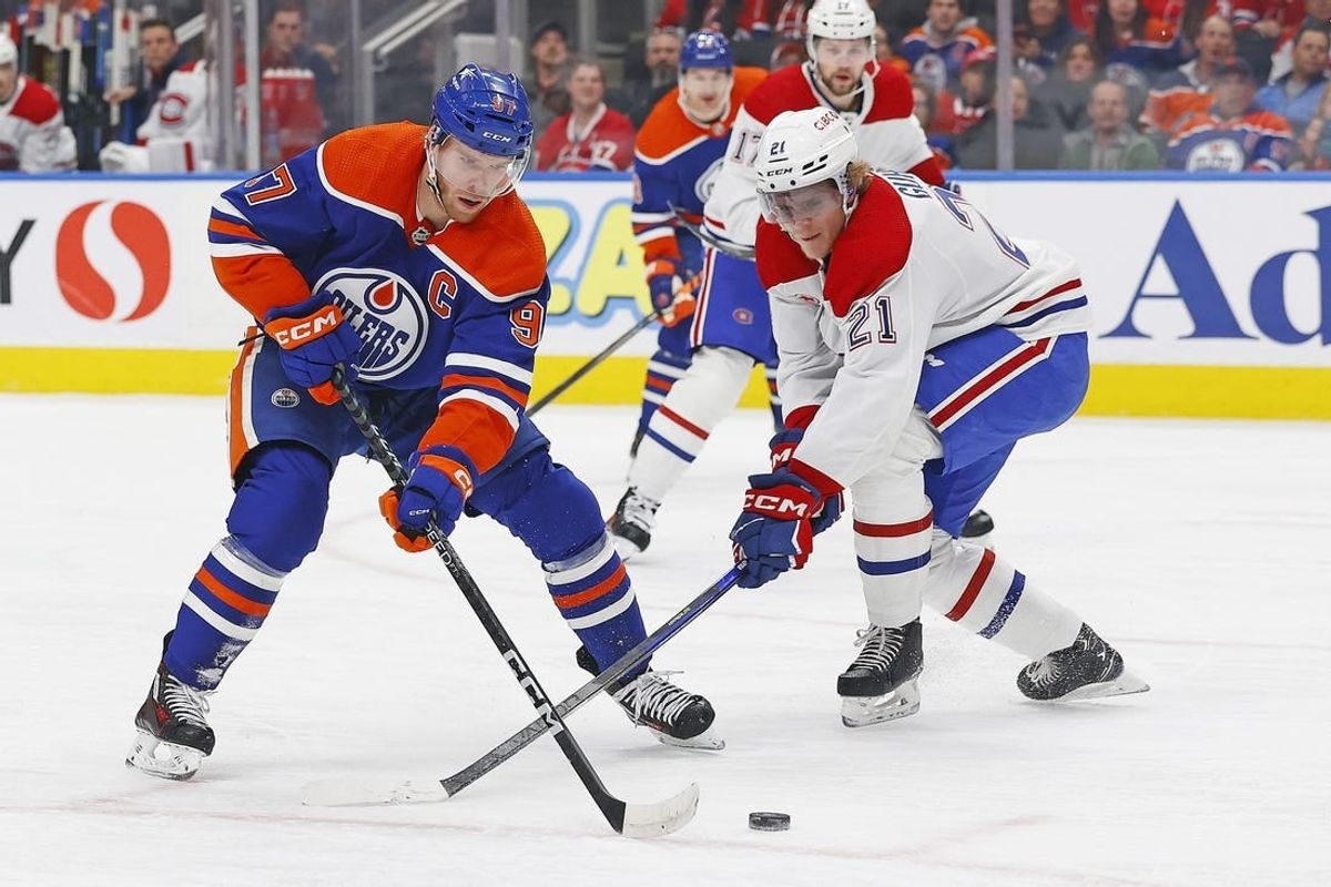 Mar 16, 2024; Edmonton, Alberta, CAN; Edmonton Oilers forward Connor McDavid (97) tries to carry the puck around Montreal Canadiens defensemen Kaiden Guhle (21) during the first period at Rogers Place.
