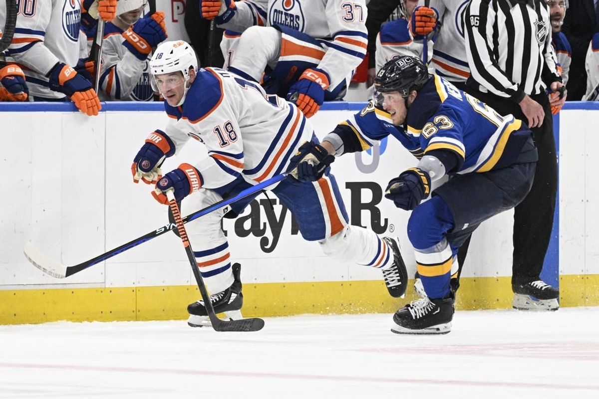 Apr 1, 2024; St. Louis, Missouri, USA; St. Louis Blues left wing Jake Neighbours (63) pressures Edmonton Oilers left wing Zach Hyman (18) during the third period at Enterprise Center.