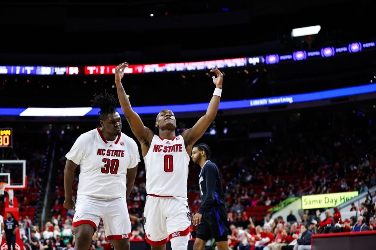 Dec 20, 2023; Raleigh, North Carolina, USA; North Carolina State Wolfpack guard DJ Horne (0) scores a three pointer and reacts with forward DJ Burns Jr. (30) during the second half against Saint Louis Billikens at PNC Arena.