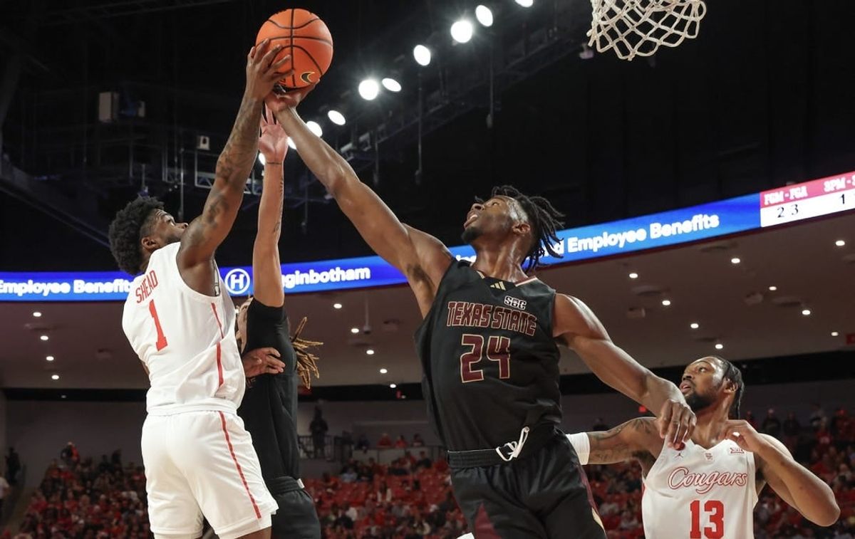 Dec 21, 2023; Houston, Texas, USA; Houston Cougars guard Jamal Shead (1) grabs defensive rebound against Texas State Bobcats forward Brandon Love (24) in the first half at Fertitta Center.