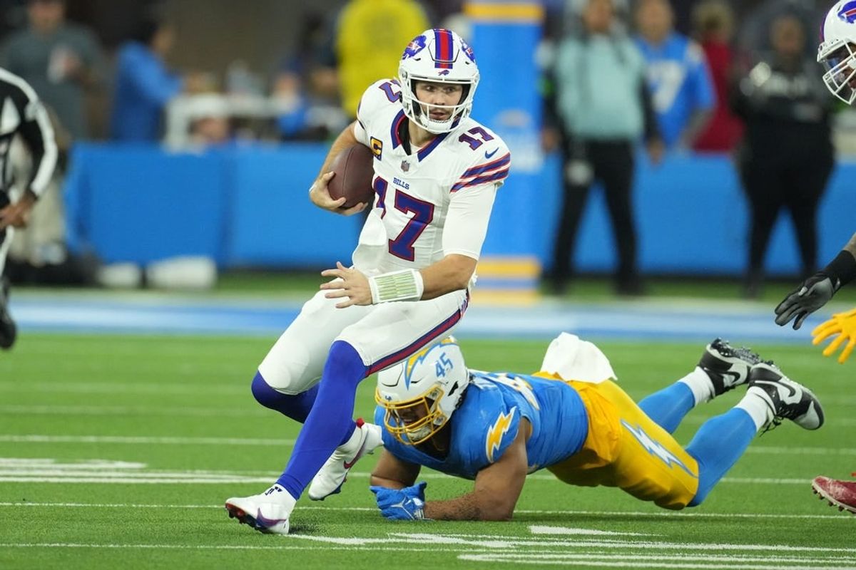 Dec 23, 2023; Inglewood, California, USA; Buffalo Bills quarterback Josh Allen (17) carries the ball against Los Angeles Chargers linebacker Tuli Tuipulotu (45) in the first half at SoFi Stadium.