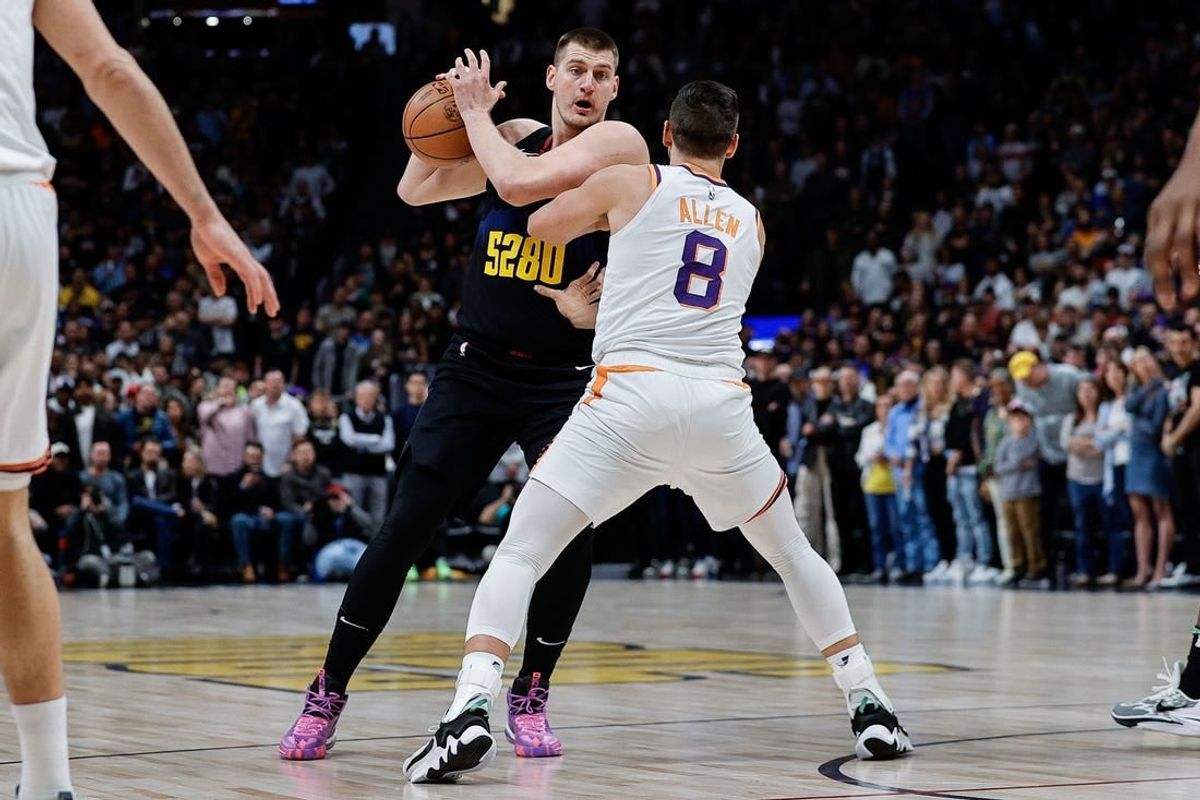 Mar 27, 2024; Denver, Colorado, USA; Denver Nuggets center Nikola Jokic (15) controls the ball as Denver Nuggets forward Peyton Watson (8) guards in the first quarter at Ball Arena.