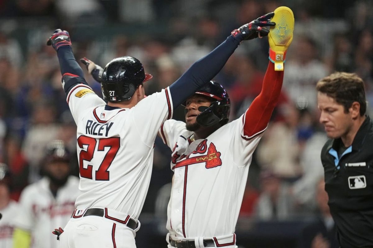 Oct 9, 2023; Cumberland, Georgia, USA; Atlanta Braves third baseman Austin Riley (27) celebrates with right fielder Ronald Acuna Jr. (13) after hitting a two run home run during the eighth inning against the Philadelphia Phillies in game two of the NLDS for the 2023 MLB playoffs at Truist Park.