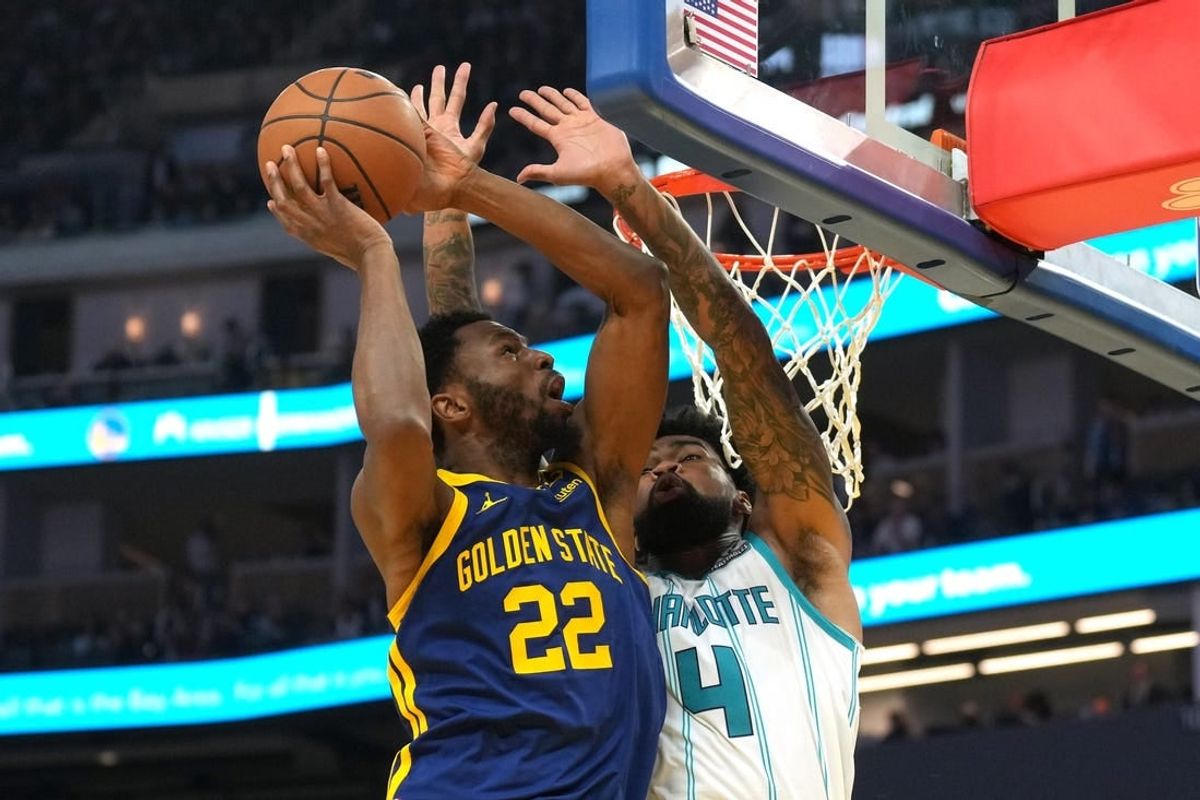 Feb 23, 2024; San Francisco, California, USA; Golden State Warriors forward Andrew Wiggins (22) shoots against Charlotte Hornets center Nick Richards (4) during the second quarter at Chase Center.