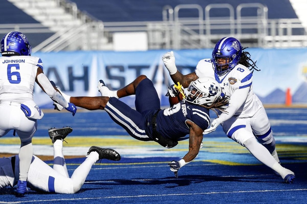 Dec 23, 2023; Boise, ID, USA; Utah State Aggies running back Rahsul Faison (3) is tackled during the first half against the Georgia State Panthers at Albertsons Stadium.