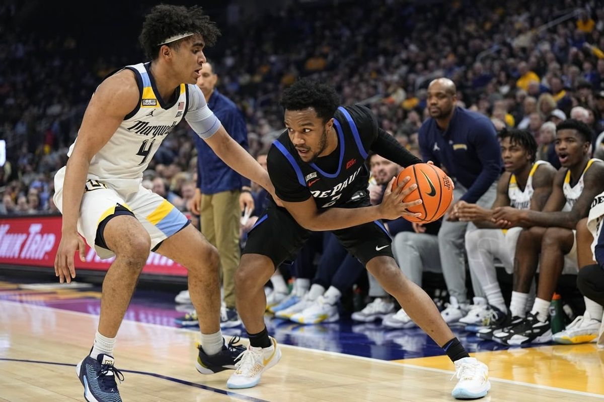 Feb 21, 2024; Milwaukee, Wisconsin, USA;  DePaul Blue Demons guard Chico Carter Jr. (2) holds the ball away from Marquette Golden Eagles guard Stevie Mitchell (4) during the first half at Fiserv Forum.