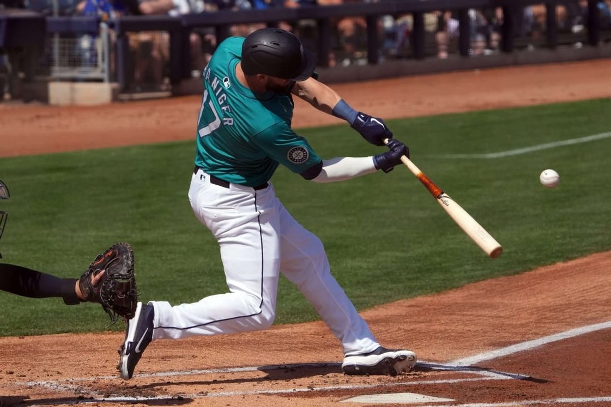 Mar 14, 2024; Peoria, Arizona, USA; Seattle Mariners left fielder Mitch Haniger (17) hits a solo home run against the Milwaukee Brewers during the first inning at Peoria Sports Complex.