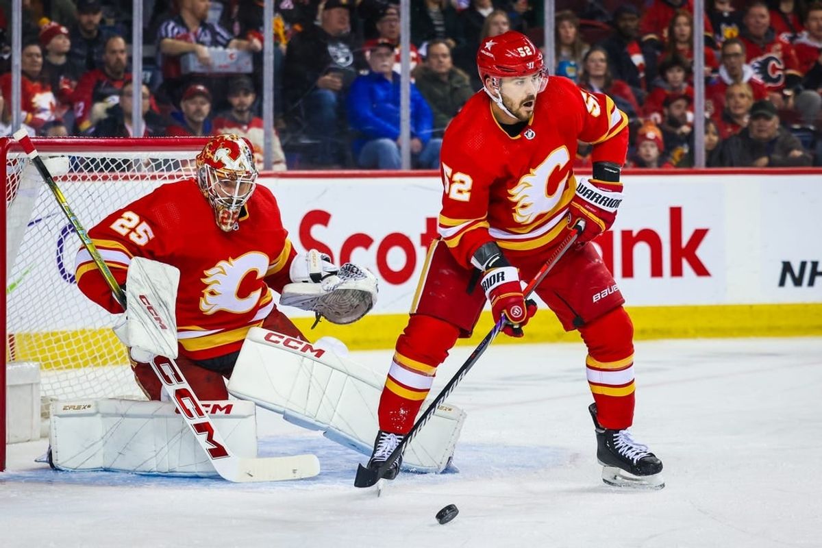 Mar 4, 2024; Calgary, Alberta, CAN; Calgary Flames defenseman MacKenzie Weegar (52) controls the puck in front of Calgary Flames goaltender Jacob Markstrom (25) during the first period against the Seattle Kraken at Scotiabank Saddledome.
