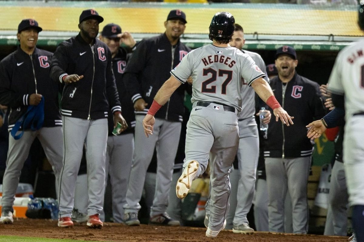 Mar 28, 2024; Oakland, California, USA; Cleveland Guardians catcher Austin Hedges (27) is greeted by his teammates after scoring on a two-RBI double by Brayan Rocchio against the Oakland Athletics during the fourth inning at Oakland-Alameda County Coliseum.
