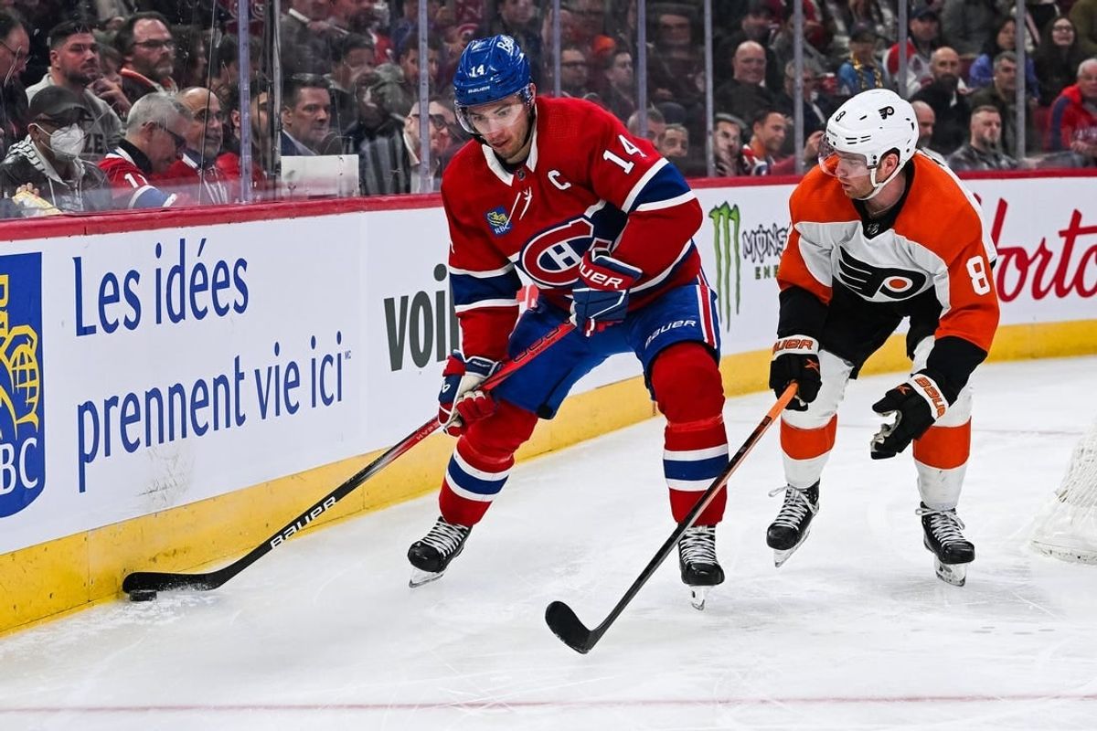 Mar 28, 2024; Montreal, Quebec, CAN; Montreal Canadiens center Nick Suzuki (14) plays the puck against Philadelphia Flyers defenseman Cam York (8) during the second period at Bell Centre.