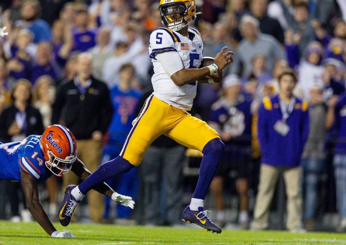 Nov 11, 2023; Baton Rouge, Louisiana, USA;  LSU Tigers quarterback Jayden Daniels (5) rushes for a touchdown against Florida Gators safety Jordan Castell (14) during the first half at Tiger Stadium.