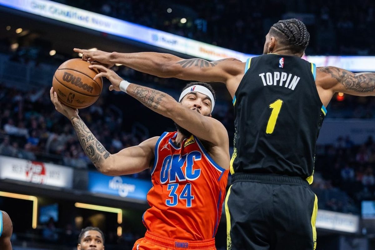 Apr 5, 2024; Indianapolis, Indiana, USA; Oklahoma City Thunder forward Kenrich Williams (34) rebounds the ball over Indiana Pacers forward Obi Toppin (1) in the first half at Gainbridge Fieldhouse.