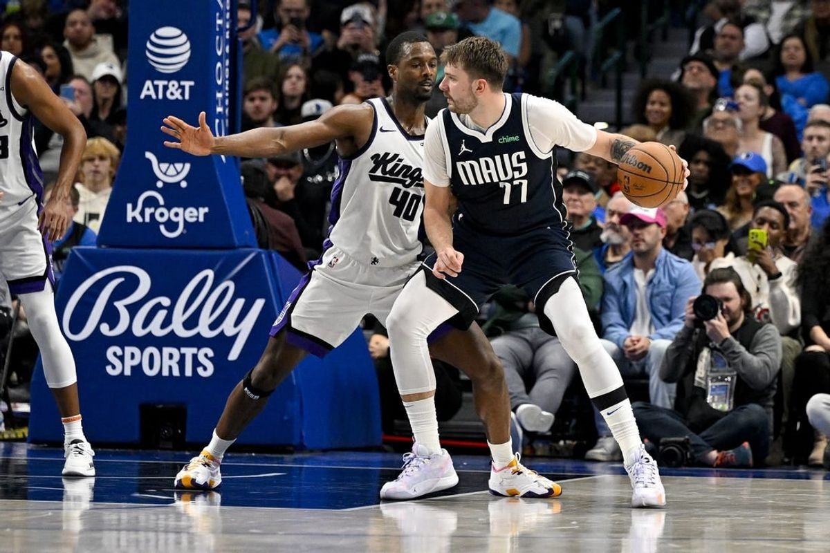 Nov 19, 2023; Dallas, Texas, USA; Dallas Mavericks guard Luka Doncic (77) looks to move the ball past Sacramento Kings forward Harrison Barnes (40) during the second half at the American Airlines Center.