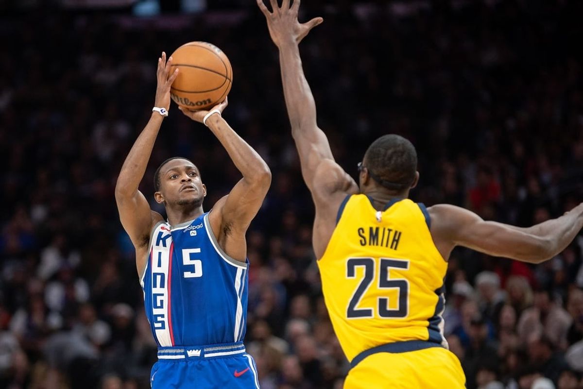 Jan 18, 2024; Sacramento, California, USA; Sacramento Kings guard De'Aaron Fox (5) takes a three point shot against Indiana Pacers forward Jalen Smith (25) during the second quarter at Golden 1 Center.
