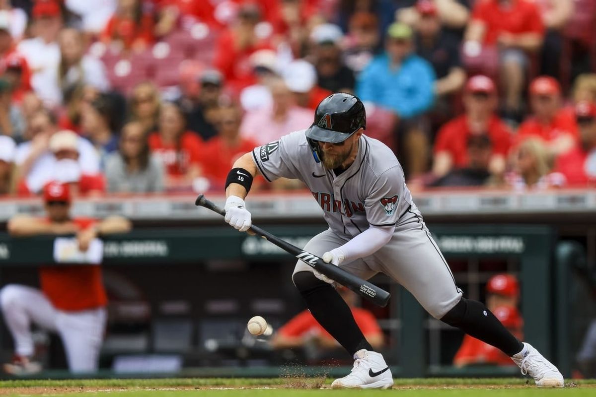 May 9, 2024; Cincinnati, Ohio, USA; Arizona Diamondbacks catcher Tucker Barnhart (16) bunts against the Cincinnati Reds in the second inning at Great American Ball Park.