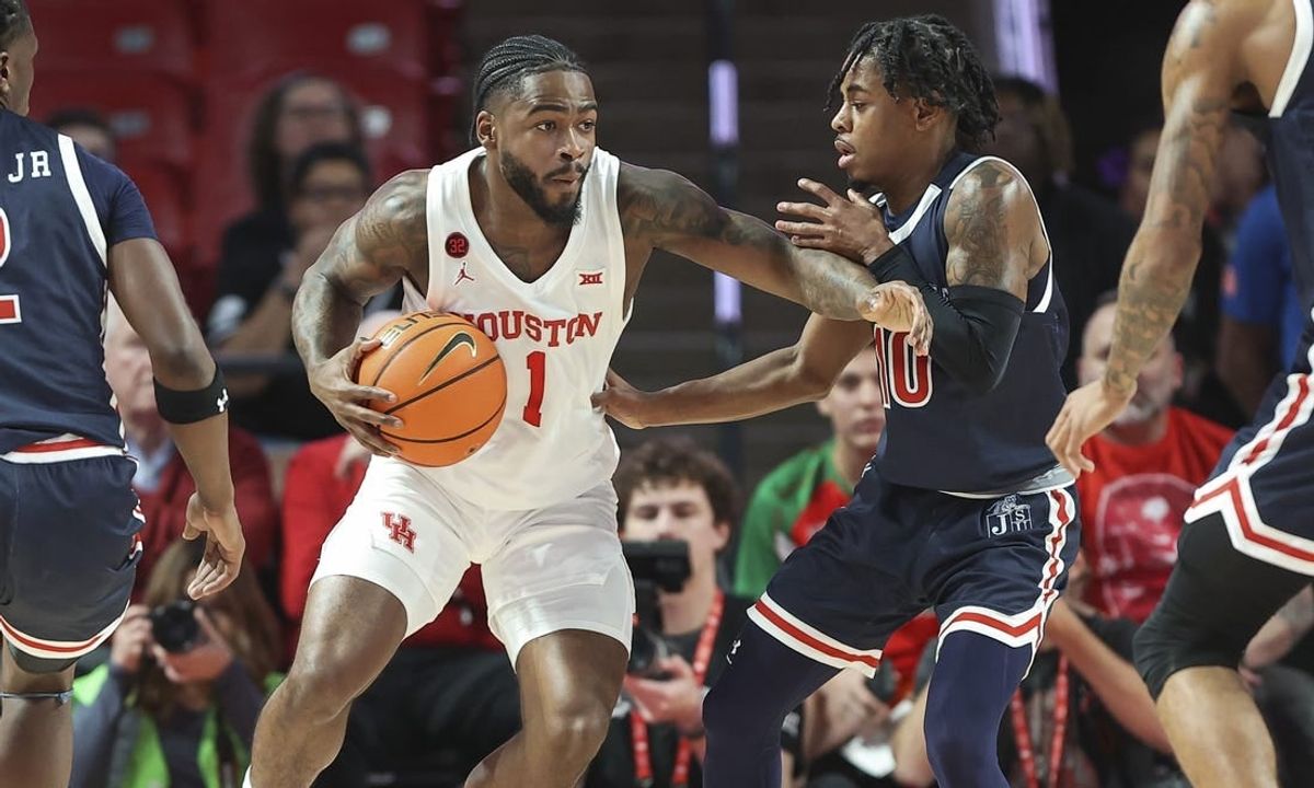 Dec 9, 2023; Houston, Texas, USA; Houston Cougars guard Jamal Shead (1) controls the ball as Jackson State Tigers guard Chase Adams (10) defends during the first half at Fertitta Center.
