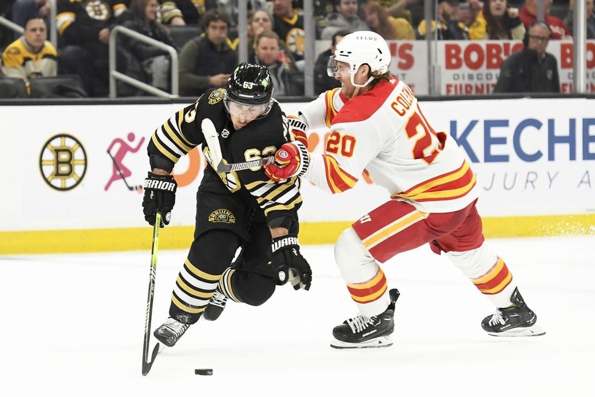 Feb 6, 2024; Boston, Massachusetts, USA; Boston Bruins left wing Brad Marchand (63) controls the puck from Calgary Flames center Blake Coleman (20) during the second period at TD Garden.