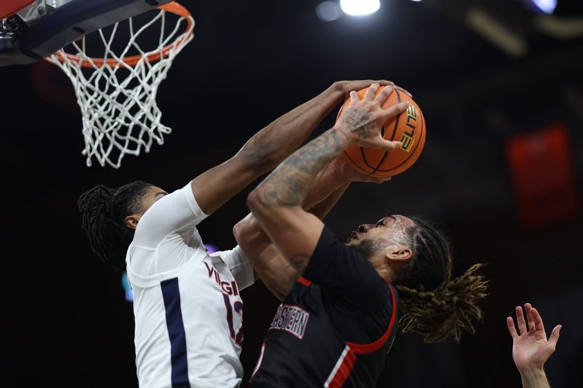 Dec 16, 2023; Charlottesville, Virginia, USA; Virginia Cavaliers guard Elijah Gertrude (12) blocks the shot of Northeastern Huskies guard Joe Pridgen (0) in the first half at John Paul Jones Arena.
