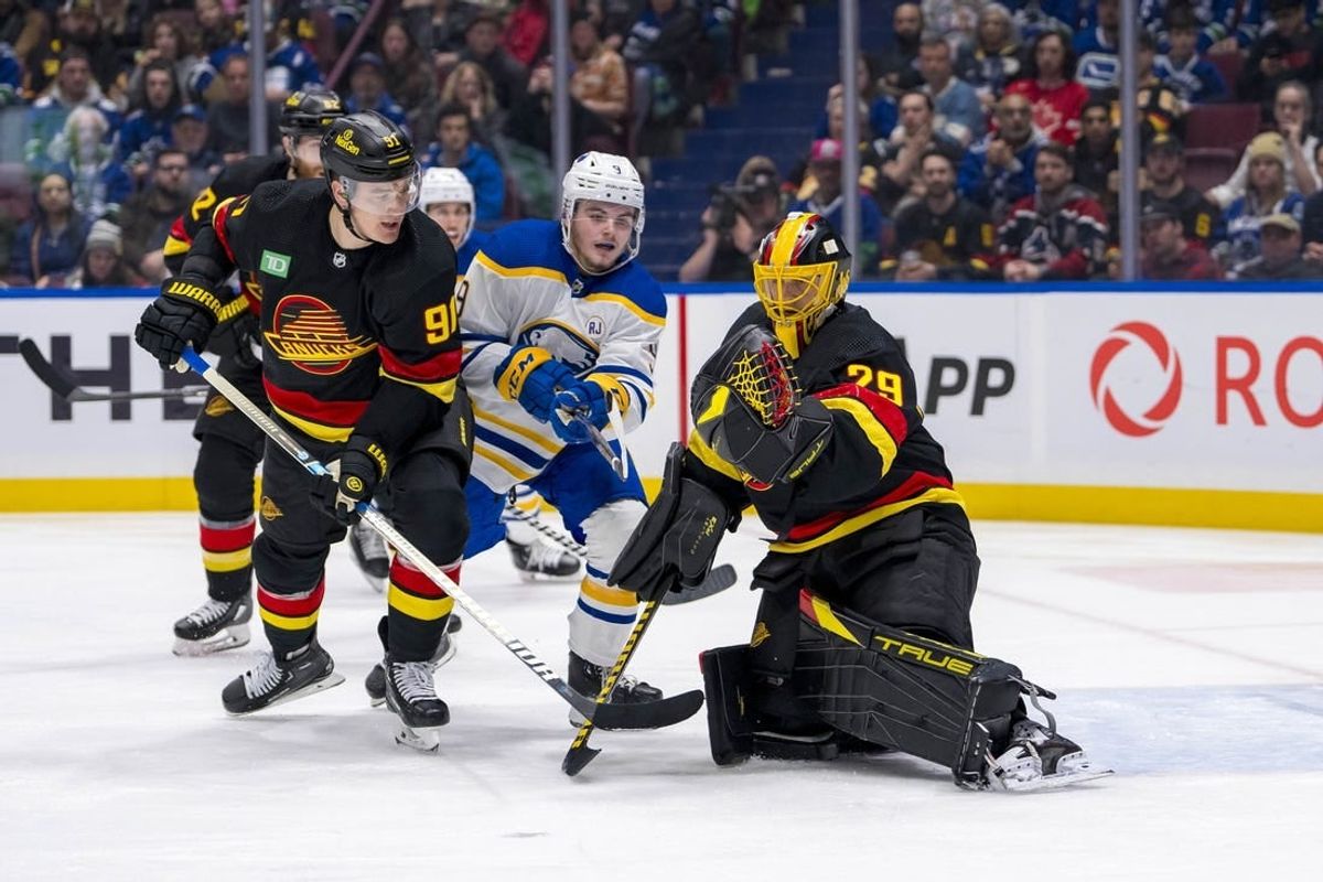Mar 19, 2024; Vancouver, British Columbia, CAN; Vancouver Canucks defenseman Nikita Zadorov (91) and Buffalo Sabres forward Zach Benson (9) watch as goalie Casey DeSmith (29) makes a save in the second period at Rogers Arena.