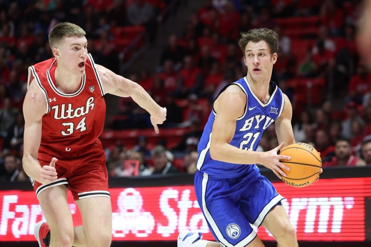 Dec 9, 2023; Salt Lake City, Utah, USA; Brigham Young Cougars guard Trevin Knell (21) dribble past Utah Utes center Lawson Lovering (34) during the first half at Jon M. Huntsman Center.