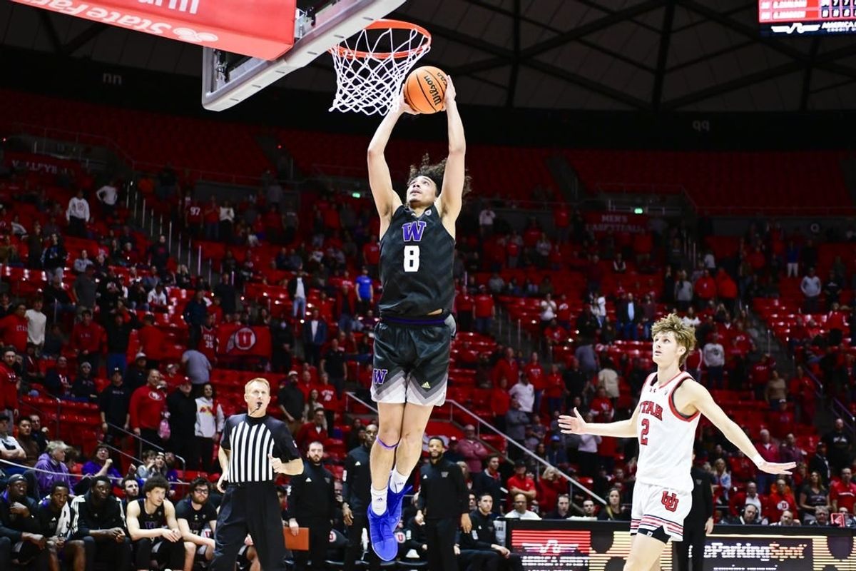 Dec 31, 2023; Salt Lake City, Utah, USA; Washington Huskies guard Nate Calmese (8) dunks over Utah Utes guard Cole Bajema (2) during the second half at the the Jon M. Huntsman Center.