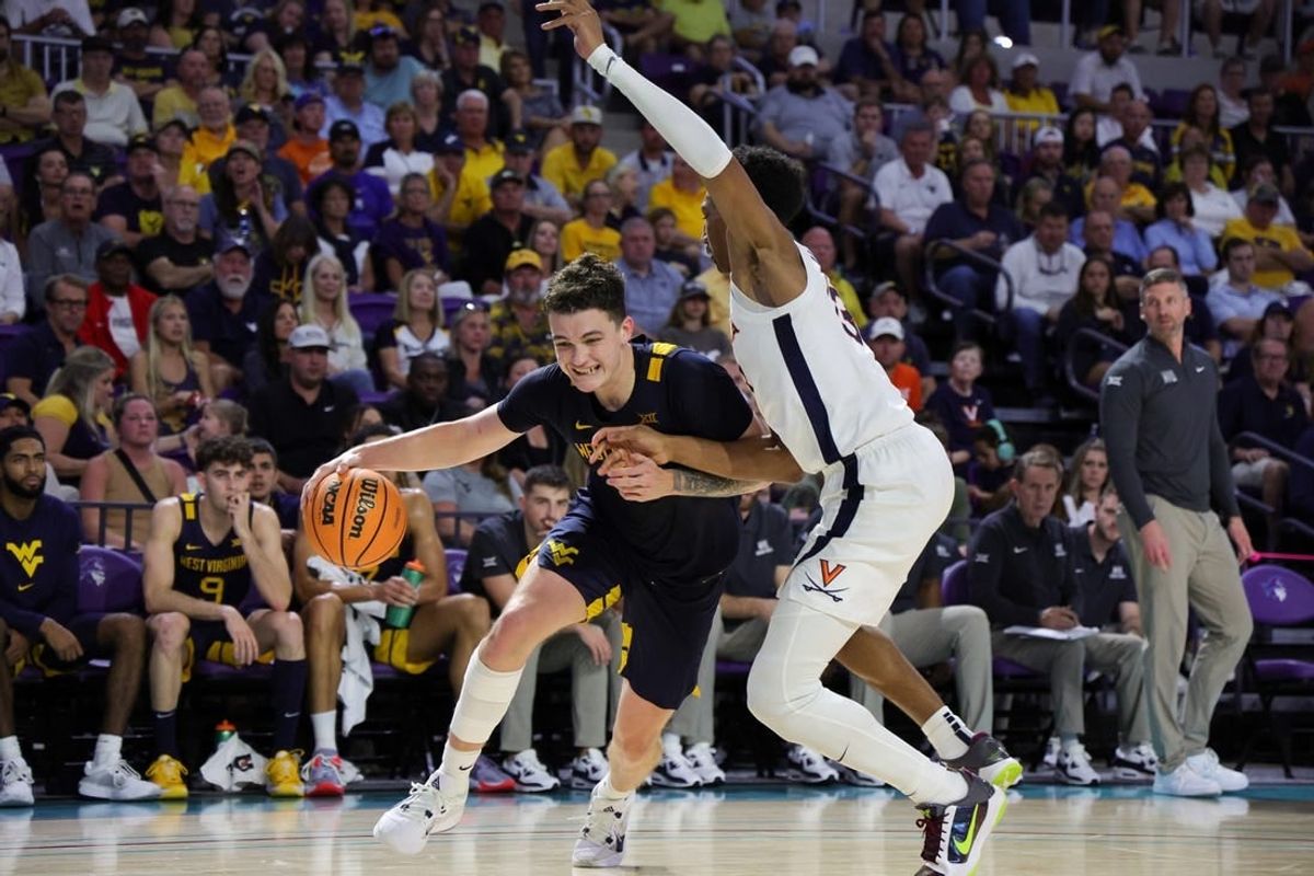 Nov 22, 2023; Fort Myers, FL, USA;  West Virginia Mountaineers forward Quinn Slazinski (11) drives to the hoop past Virginia Cavaliers guard Ryan Dunn (13) in the second half during the Fort Myers Tip-Off third place game at Suncoast Credit Union Arena.