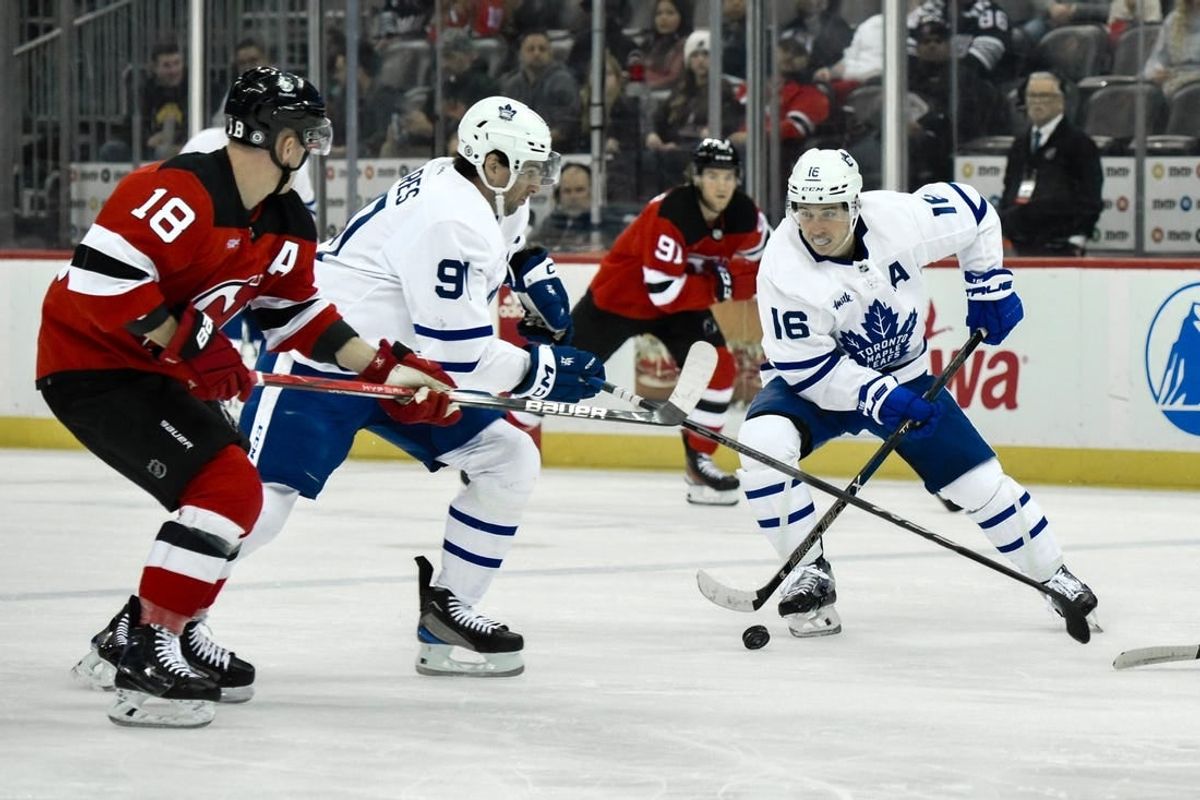 Apr 9, 2024; Newark, New Jersey, USA; Toronto Maple Leafs right wing Mitch Marner (16) skates with the puck while being defended by New Jersey Devils left wing Ondrej Palat (18) during the first period at Prudential Center.