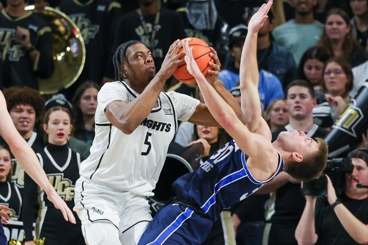 Jan 13, 2024; Orlando, Florida, USA; Brigham Young Cougars guard Dallin Hall (30) is fouled by UCF Knights forward Omar Payne (5) during the first period at Addition Financial Arena.