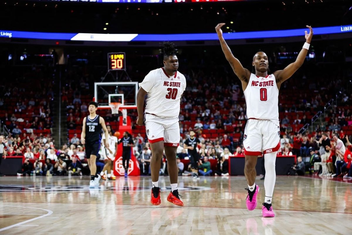 Dec 20, 2023; Raleigh, North Carolina, USA; North Carolina State Wolfpack guard DJ Horne (0) scores a three pointer and reacts with forward DJ Burns Jr. (30) during the second half against Saint Louis Billikens at PNC Arena.