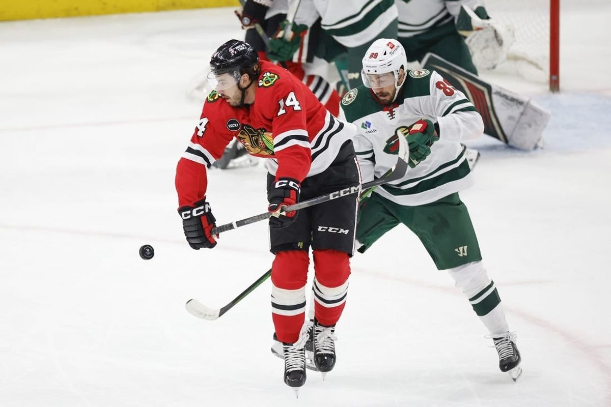 Feb 7, 2024; Chicago, Illinois, USA; Chicago Blackhawks left wing Boris Katchouk (14) battles for the puck with Minnesota Wild center Frederick Gaudreau (89) during the first period at United Center.