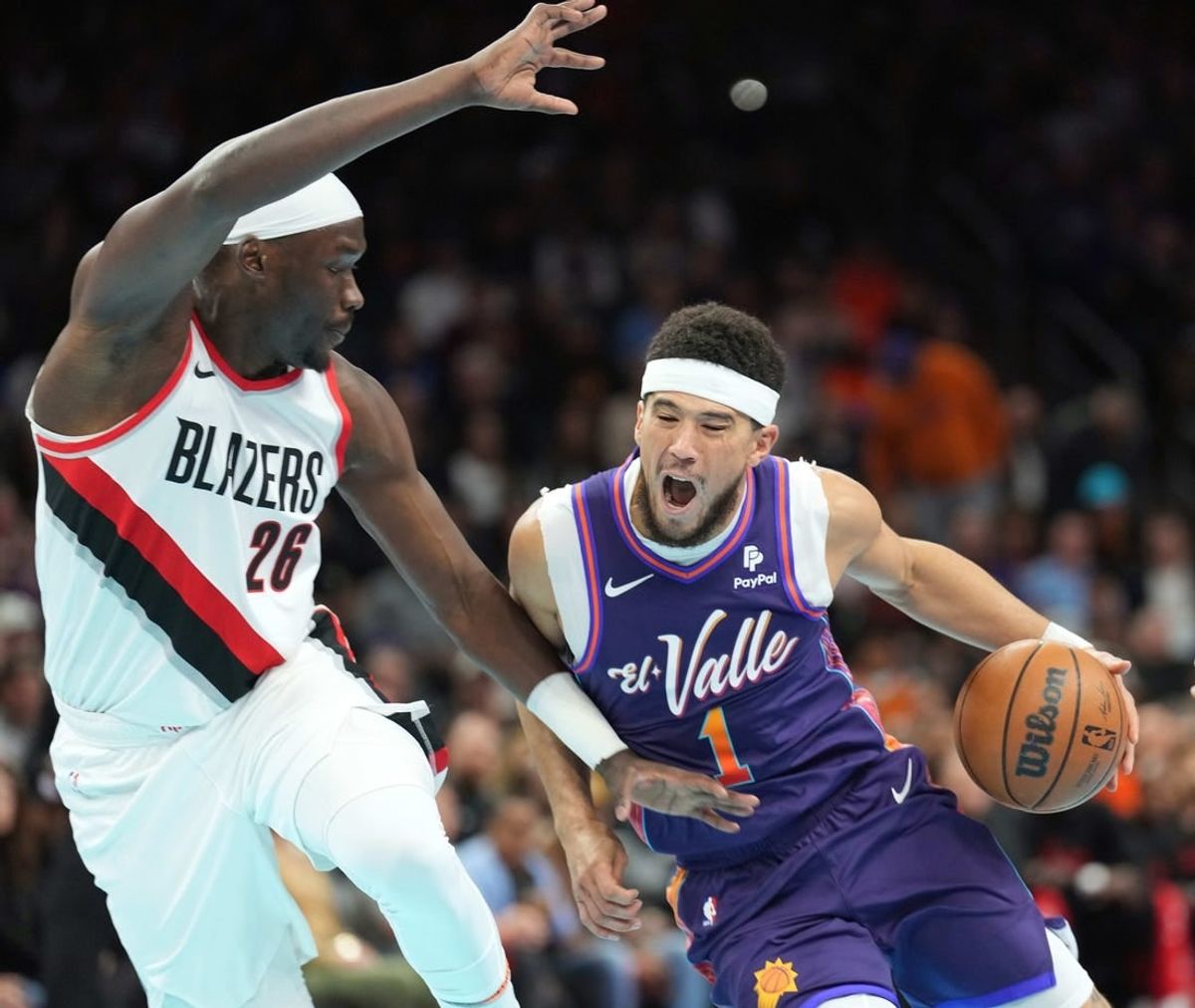 Nov 21, 2023; Phoenix, Arizona, USA; Phoenix Suns guard Devin Booker (1) dribbles against Portland Trail Blazers center Duop Reath (26) during the first half at Footprint Center.