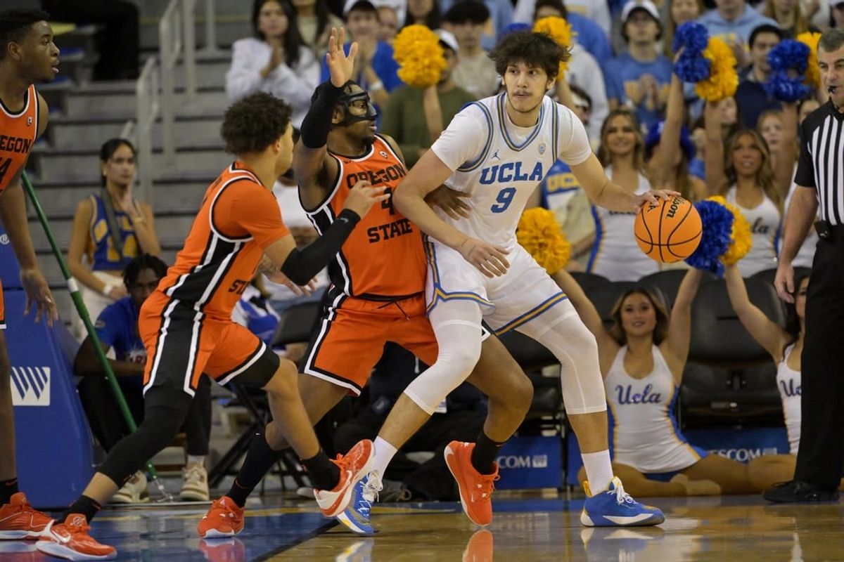 Feb 1, 2024; Los Angeles, California, USA; Oregon State Beavers guard Jordan Pope (0) and guard Dexter Akanno (4) defend UCLA Bruins forward Berke Buyuktuncel (9) in the first half at Pauley Pavilion presented by Wescom.